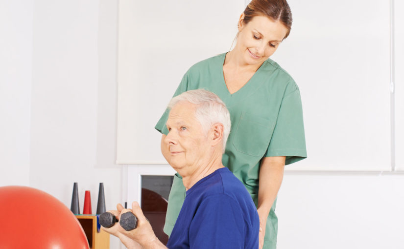 37735424 - old man with dumbbells on gym ball in a physical therapy praxis